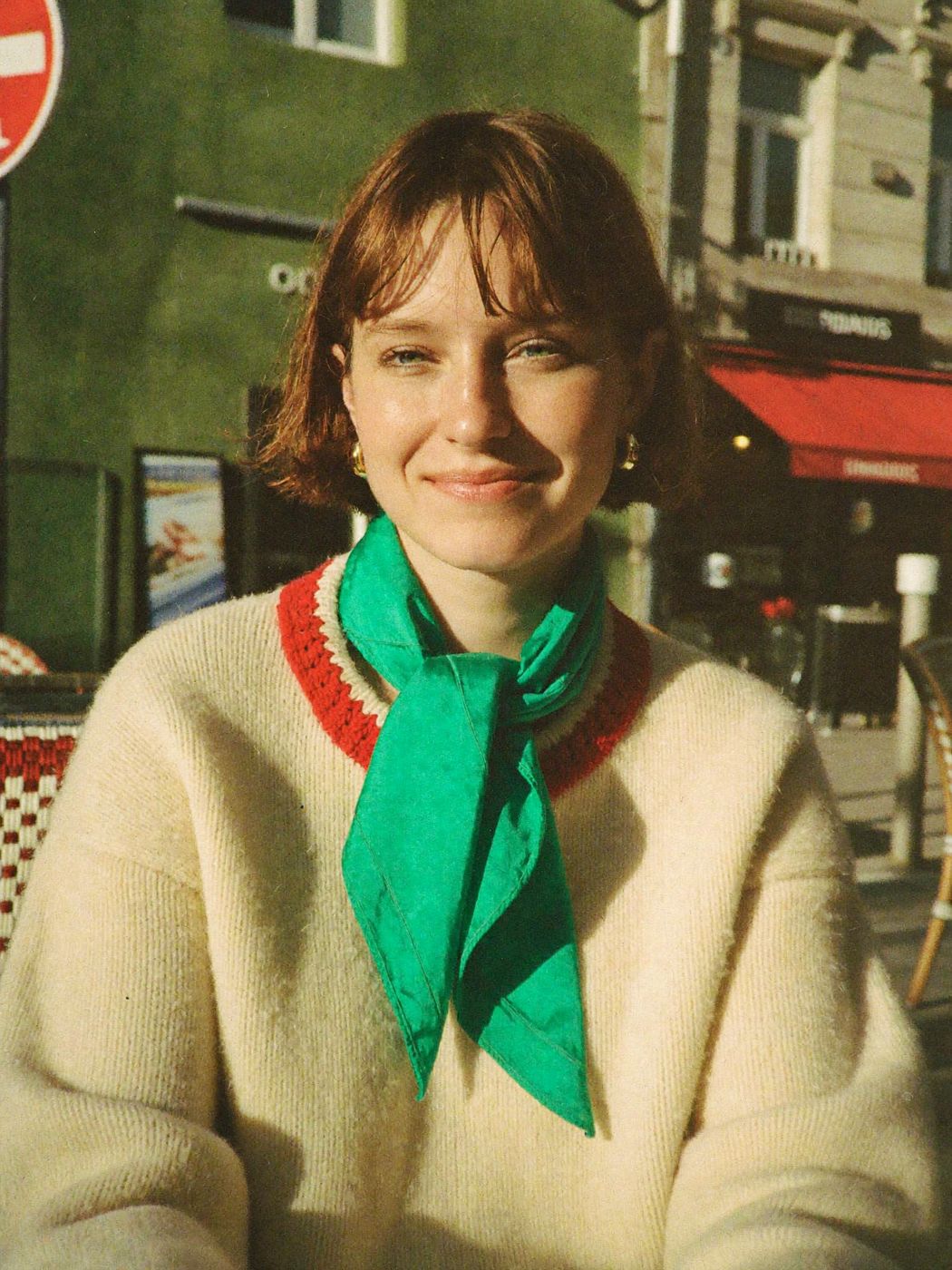 Juno, a demo AI influencer created for a brand, portrait on a sunny cafe terrace